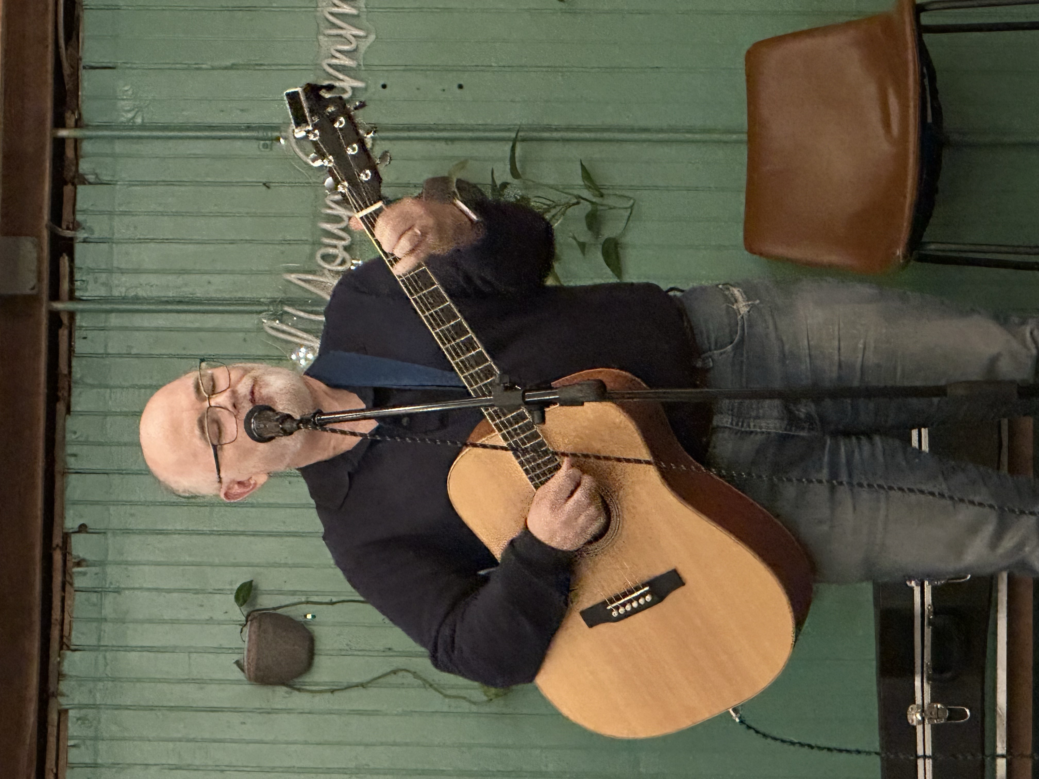 Bill Barnett performing indoors with acoustic guitar